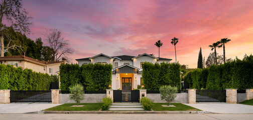 Wall Mural - an outside view of a home in the sunset with palm trees