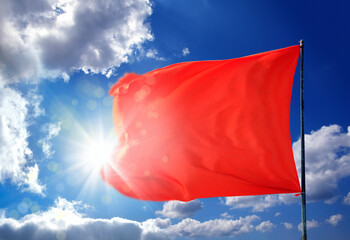 Wall Mural - Conceptual image of waving blank red flag over sunny blue sky