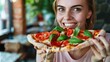 Young Caucasian suntanned beautiful elegant woman eating, biting Italian thick tomato pizza with burata cheese Yummy unhealthy food.