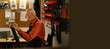 Male senior mechanic working in bicycle repair shop, old man repairing bike using special tool in workshop. Copy space