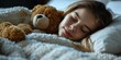 A peaceful, adorable preteen girl sleeps with a teddy bear in a cozy bedroom.