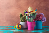 Fototapeta  - Mexican party concept with cactus and sombrero hat on wooden blue table over wall background. Cinco de Mayo holiday celebration