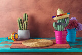 Fototapeta  - Empty wooden table with place mat  and cactus decoration over wall  background. Mexican party mock up for design and product display