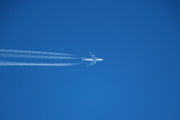 Wall Mural - Airplane in the blue sky with contrail