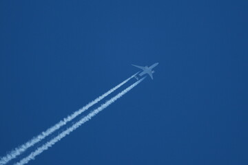 Wall Mural - Airplane in the blue sky with contrail