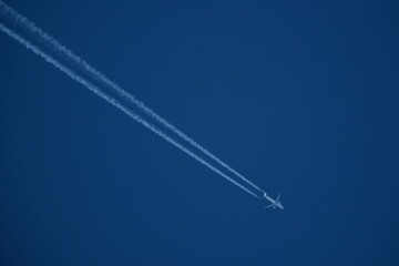 Wall Mural - Airplane in the blue sky with contrail