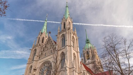 Poster - St. Paul's Church or Paulskirche timelapse. Looking up perspective. A large Catholic church in the Ludwigsvorstadt-Isarvorstadt quarter of Munich, Bavaria, Germany. View from side with clock tower