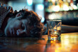Drunk man holding a drink and sleeping on a bar counter