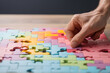 Hand placing a part of  colorful jigsaw puzzle