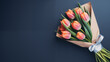 a bouquet of tulips wrapped in white paper with a ribbon on a dark blue background, Mother's Day concept
