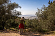 Woman is is using her smartphone to make a photo of  the view of Athens city from Hymettus mountain. .