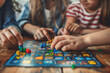 © Usama - A cute sister and brother's hands playing a board game, strategizing and having a great time.