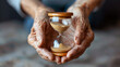 Older hands holding hourglass