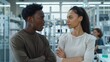 © BrightWhite - Two colleagues having a discussion in an industrial setting, diverse workplace team, modern factory environment, male and female professionals.