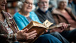 Elderly people enjoying a book reading together, focus on open book.
