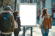 © K2Kstock - A group of young people walking in the city and looking at a blank billboard