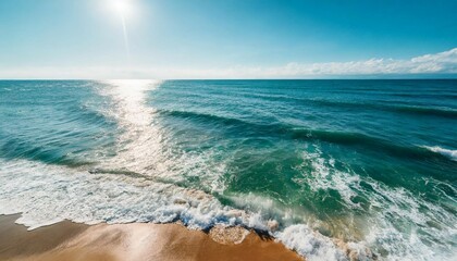 Summer seascape beautiful waves, blue sea water in sunny day. Top view from drone. Sea aerial view, amazing tropical nature background. Beautiful bright sea with waves splashing and beach sand