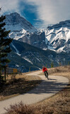 Fototapeta  - A woman rides a bike on the Legacy Trail, which runs from Canmore to Banff in Alberta, Canada.