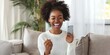 Exuberant young woman with afro hairstyle winning on smartphone at home.