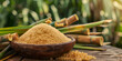Sugarcane and brown sugar on a wooden background closeup