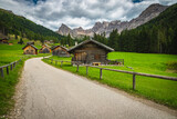 Fototapeta Tęcza - Wooden log huts and majestic mountains in San Nicolo valley