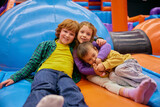 Fototapeta Nowy Jork - Cute little kids of different age playing on inflatable bounce house