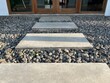 Rectangle stepping stones with gravel stone pebbles floor leading towards building entrance