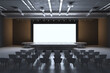 © Who is Danny - Modern event hall with blank screen on stage and scattered seating arrangement. 3D Rendering