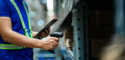 A man in a blue shirt is using a barcode scanner to scan a product. Concept of efficiency and productivity, as the man is using technology to quickly and accurately identify the product