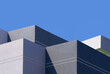 High section of gray and white buildings group in geometric shape with sunlight and shadow on surface against blue clear sky background, Exterior architecture in minimal style