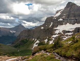 Poster - Beautiful shot of a flowing creek among stones in Glacier National Park in Montana