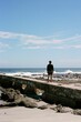 © Wirestock - Vertical shot of a man admiring the view of a sea on a sunny day