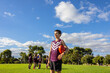 © Austockphoto - one boy standing with football under his arm with teammates and coach in background