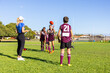 © Austockphoto - woman wearing activewear training kids football team