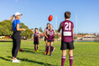 © Austockphoto - woman wearing activewear supervising kids football training