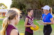 © Austockphoto - football coach training school-aged children on playing field