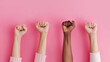 Women's Day, a female raised fist isolated on a pink background. 