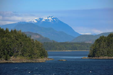 Wall Mural - Panoramic morning or day time landscape nature coastal scenery with beautiful blue sky and dramatic cloudscapes in Alaska Inside Passage glacier mountain range view during cruise