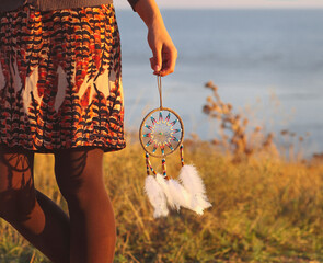 Brunette woman with long hair holding dream catcher