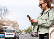 © Barillo_Images - Mobility as a service. Urban woman searches rental car, rental transport using her smart phone.