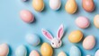 Easter party concept. Top view photo of Easter bunny ears white pink blue and yellow eggs on isolated pastel blue background