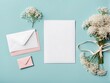  Wedding mockup with a white paper list and flowers gypsophila on the coloured table top view flat lay. Blank greeting cards and envelopes design. Beautiful floral pattern. Flat lay style design. 