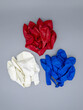 Three colors of deflated latex balloons white blue red on a gray background