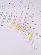 A calendar sheet with dates and candles for the cake are on the table among the sprinkles, a place for text