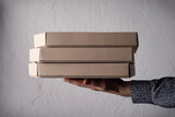 Fototapeta  - Caucasian male hands hold three pizza boxes side view with copy-space