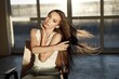 Brunette woman sitting on a chair and brushing her hair