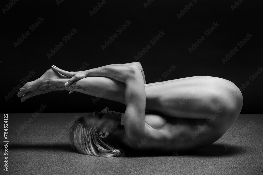 Art black and white photo of naked beautiful woman. Beauty nude yoga girl posing on black