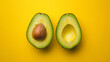 Fresh avocado cut in half, its vibrant green and creamy texture contrasting against a bold yellow background.