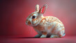 A cute little bunny with brown and white fur is sitting on a red background