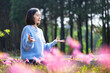 Asian woman is doing meditation mudra in the forest with spring bulb flower in blooming season for inner peace, mindfulness and zen practice